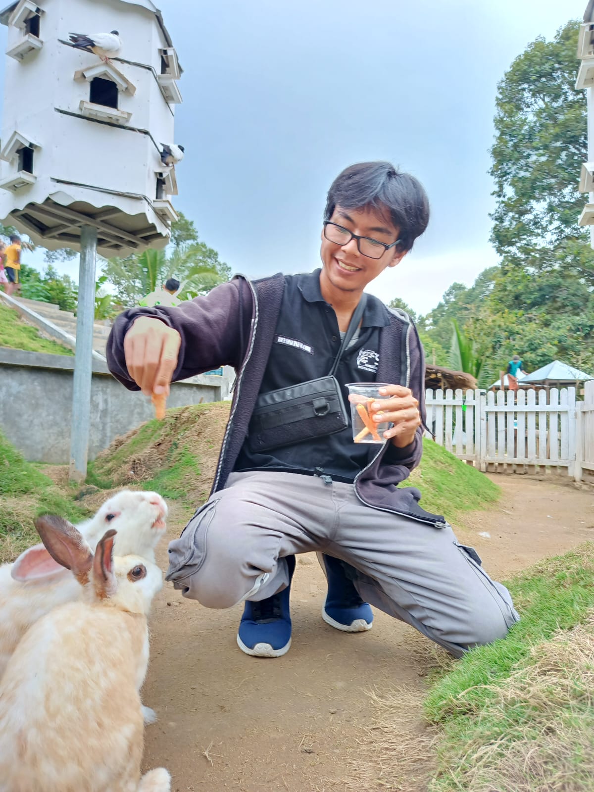 Salah satu pengunjung tengah menikmati sensasi memberikan pakan ternak kelinci di Farmday || Foto: 5W1HINDONESIA.ID