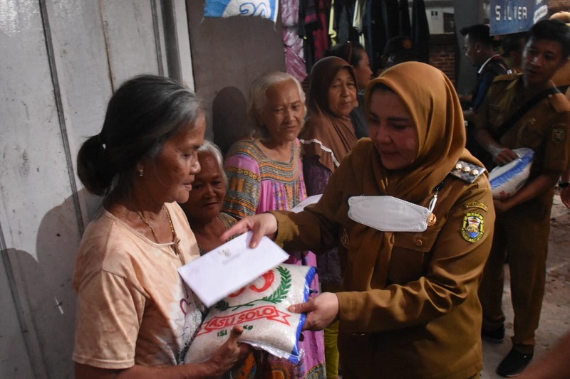 Walikota Eva Dwiana memberikan bantuan uang tunai dan beras 5kg untuk warga terdampak banjir || Foto: Dok. Prokopim