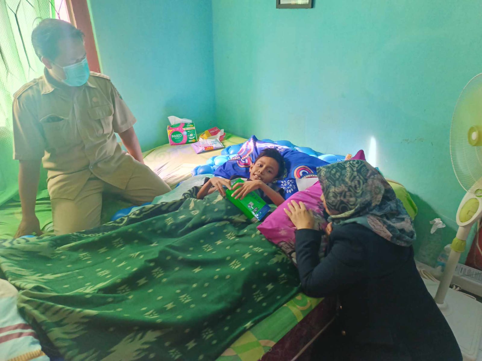 Adnan Jaya (11) saat melakukan perawatan di rumahnya di dampingi oleh dokter dari Puskesmas Kebon Jeruk || Foto: 5W1HINDONESIA.ID