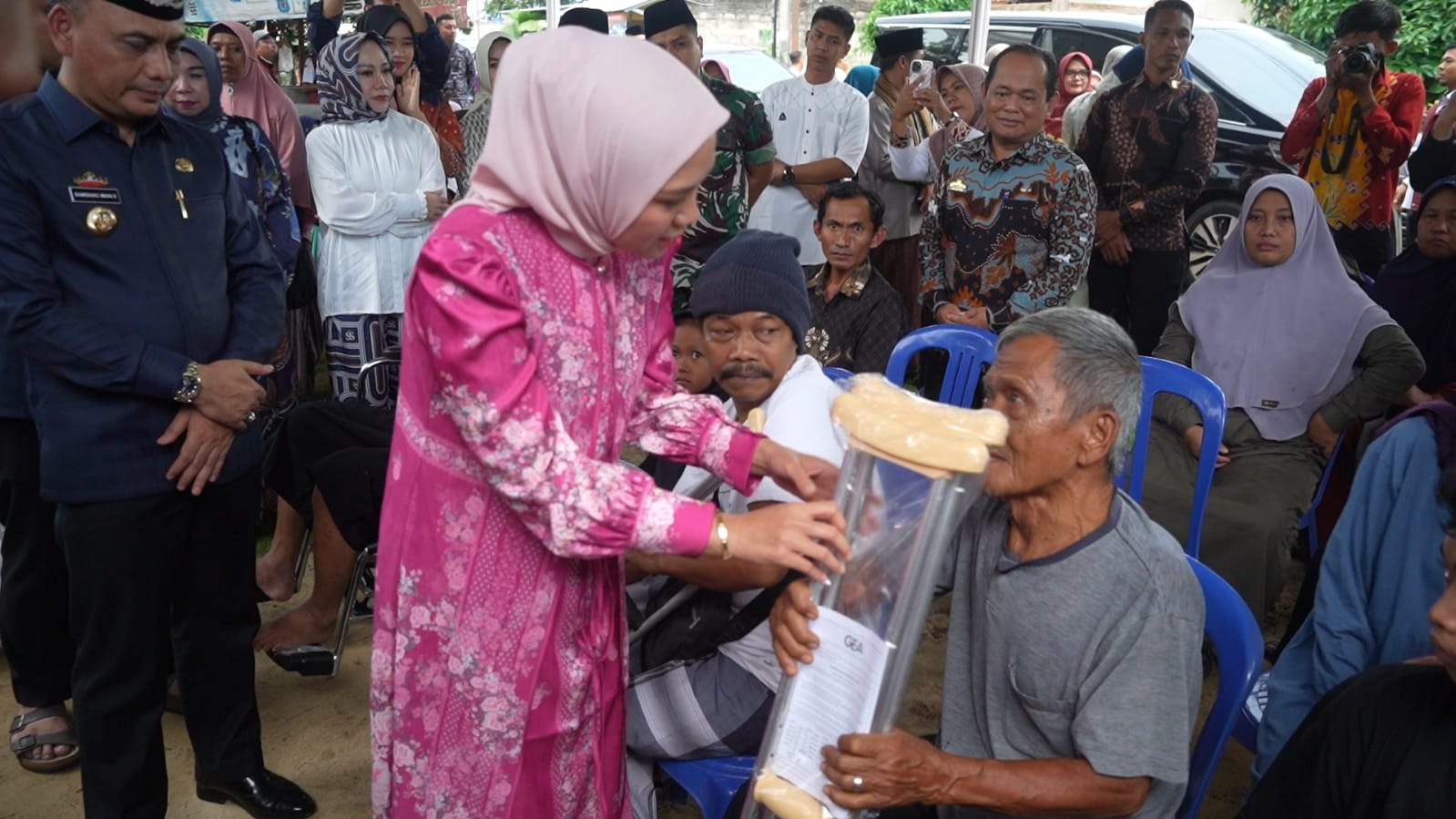 Ketua Tim Penggerak PKK Provinsi Lampung, Purnama Wulan Sari Mirza, menyerahkan bantuan kepada Maryono, salah satu penerima bantuan tongkat kruk, yang merupakan penyandang disabilitas fisik || Foto: Dinas Kominfotik Provinsi Lampung