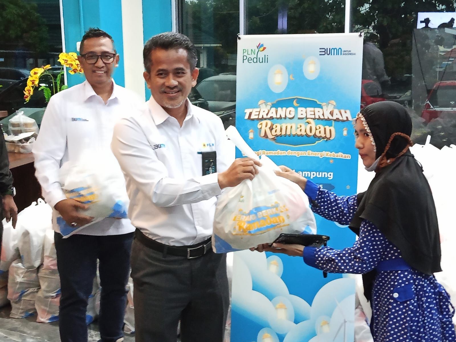 GM PLN UID Lampung (tengah) Muhammad Joharifin di dampingi Manager Komunikasi dan TJSL (kiri) Darma Saputra, tengah terjun melakukan penyerahan secara langsung Paket Sembako kepada salah satu penerima manfaat Program Pasar Murah Terang Berkah Ramadhan || Foto: PLN UID Lampung