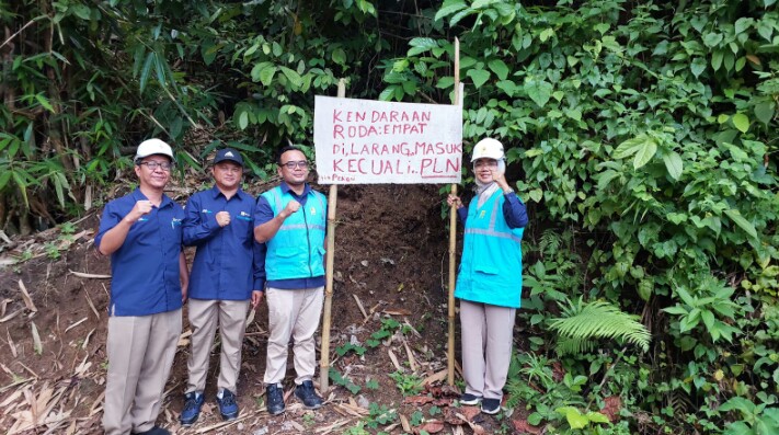 Manager UP3 Pringsewu Eka Nurwati dan tim berfoto pada rambu darurat sebagai bentuk apresiasi atas dukungan masyarakat Atar Lebar, Tanggamus yang membantu membuka jalur untuk dapat dilewati kendaraan PLN || Foto: PLN UP3 Pringsewu