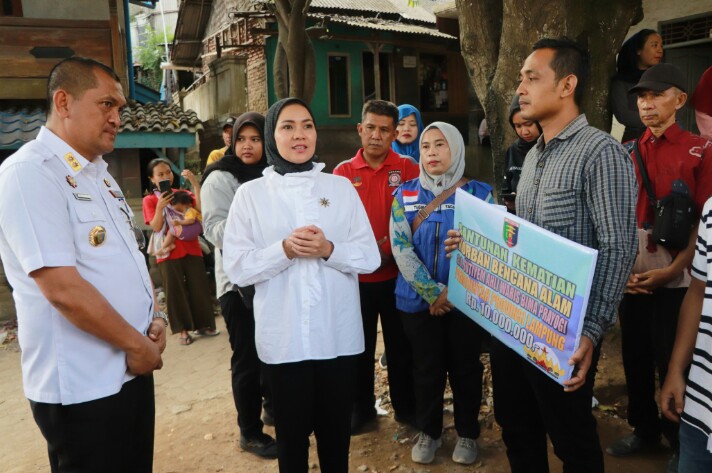 Ketua TP PKK Provinsi Lampung, Purnama Wulan Sari Mirza menyerahkan bantuan sosial kepada ahli waris korban banjir di Kampung Sinar Binglu, Way Lunik, PanjangKet || Foto: Dinas Kominfotik Provinsi Lampung