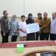 Kepala Dinas Kominfotik Provinsi Lampung, GanjarJationo, bersama Kepala Cabang BPJS Ketenagakerjaan Bandar Lampung, M. Nuh menyerahkan Santunan Jaminan Kematian (JKM) dan Beasiswa kepada ahli waris PTHL Dinas Kominfotik Provinsi Lampung atas nama Pandu Krisna Muharwan || Foto: Dinas Kominfotik Provinsi Lampung