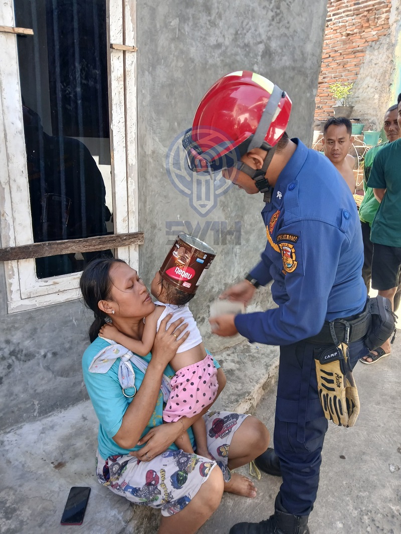 Tim Rescue dari Damkarmat kota Bandar Lampung sedang mengevakuasi kaleng yang tersangkut di kepala seorang balita || Foto: 5W1HINDONESIA.ID