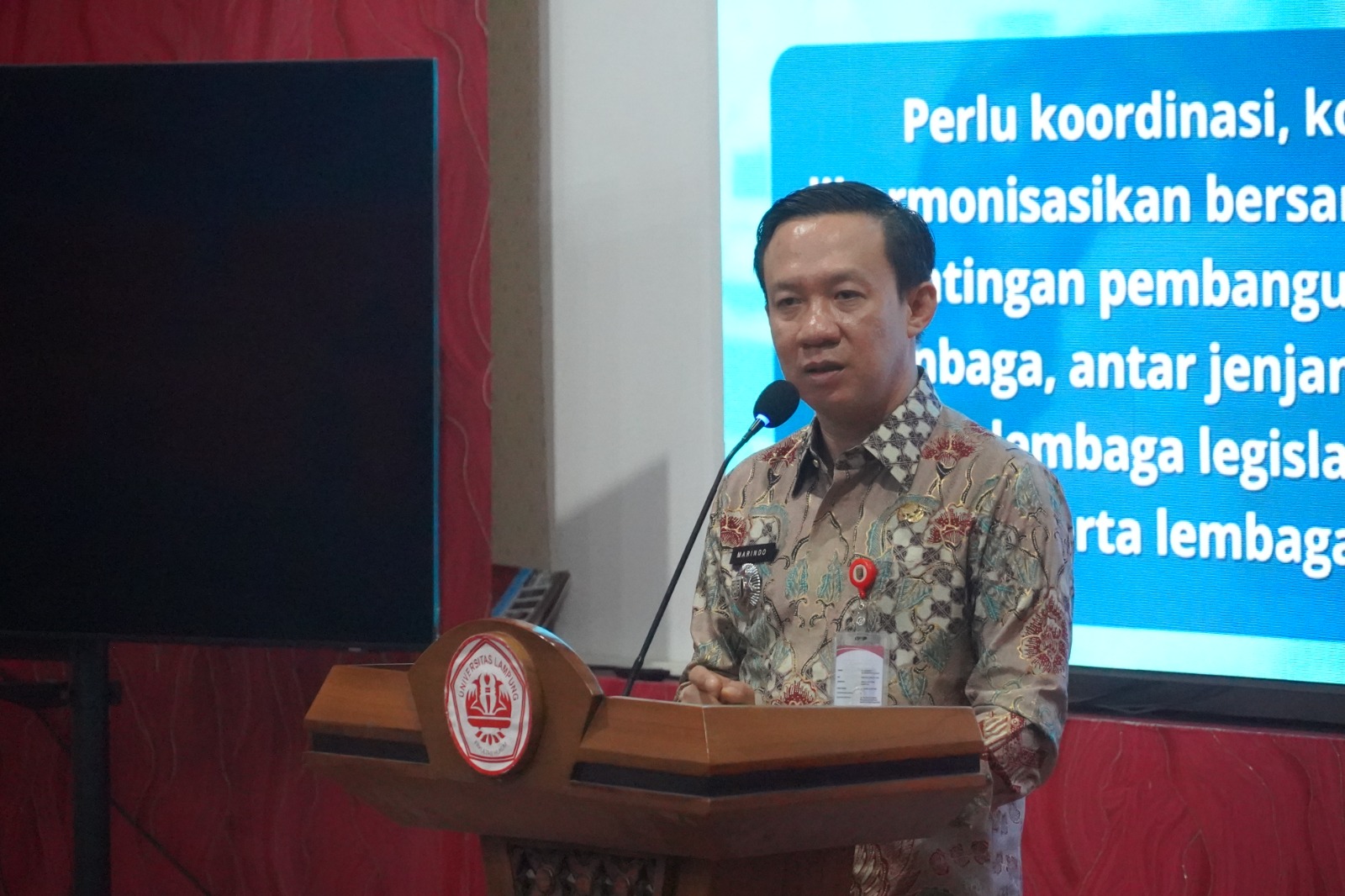 Sekdaprov Lampung, Marindo Kurniawan, saat menjadi keynote speaker pada kegiatan Lampung Digital Education Transformation Symposium (LEDTS) 2026, yang digelar di Hall Fakultas Hukum Universitas Lampung || Foto: Dinas Kominfotik Provinsi Lampung
