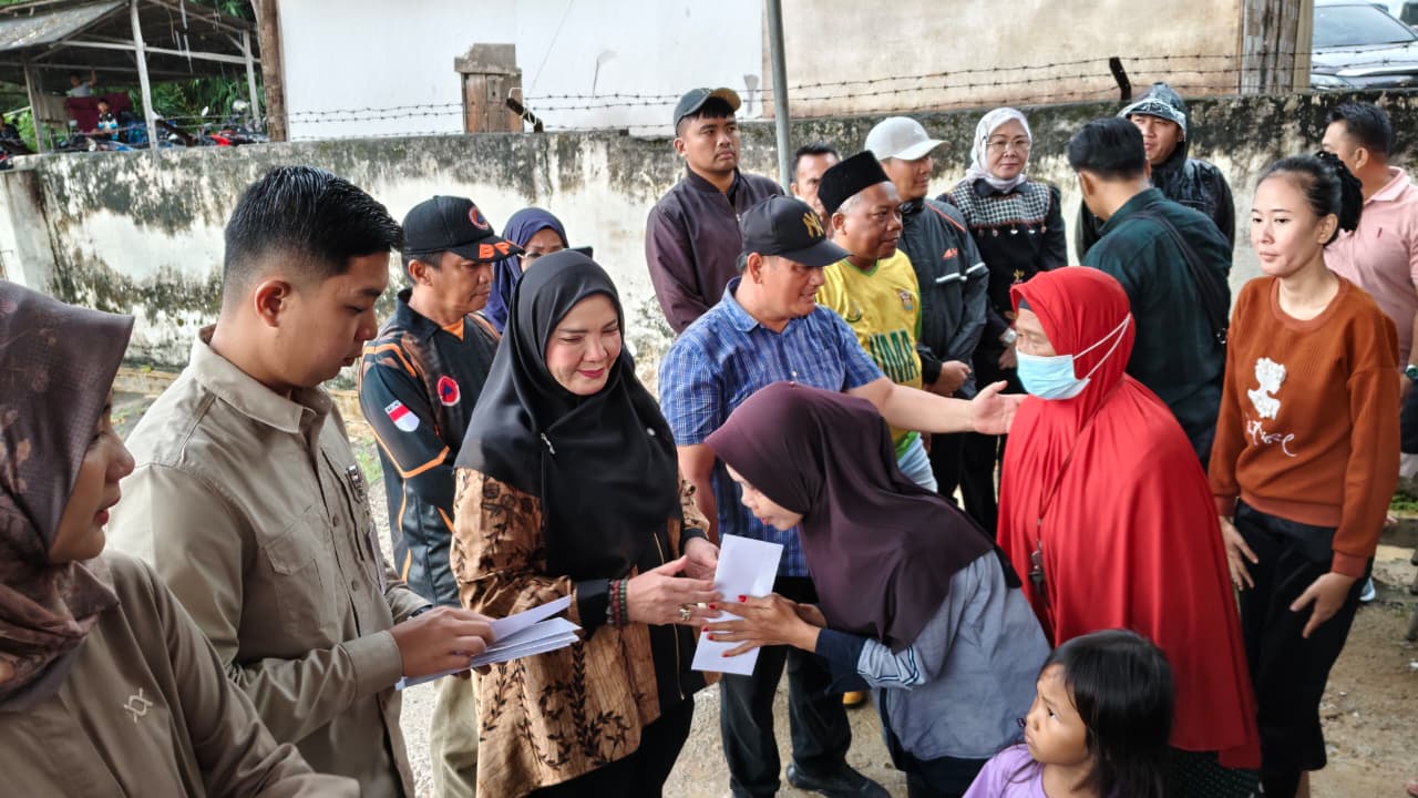 Walikota Eva Dwiana saat menyalurkan beras dan uang tunai kepada korban banjir || Foto: 5W1HINDONESIA.ID