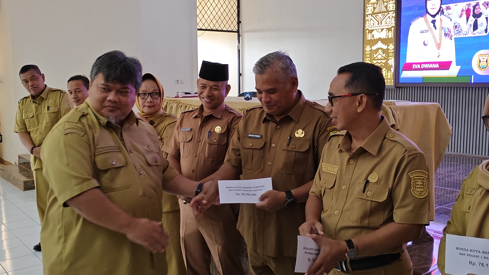 Plt. Kadisdikbud, Moh. Ramdan menyalurkan BOSDA yang bersumber dari dana APBD kota Bandar Lampung || Foto: Ridho/5W1HINDONESIA.ID